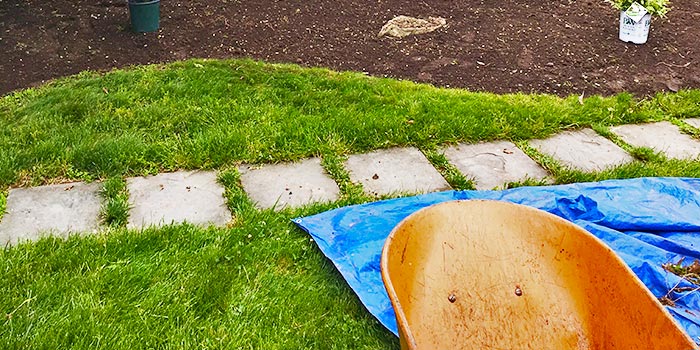 Greenscapes Landscape Management installing mulch with a wheel barrow.